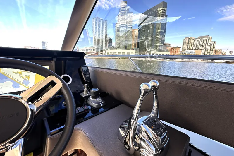 Slide: The Image of Interior view of 2023 Prestige 590 yacht helm with cityscape in background. - 53