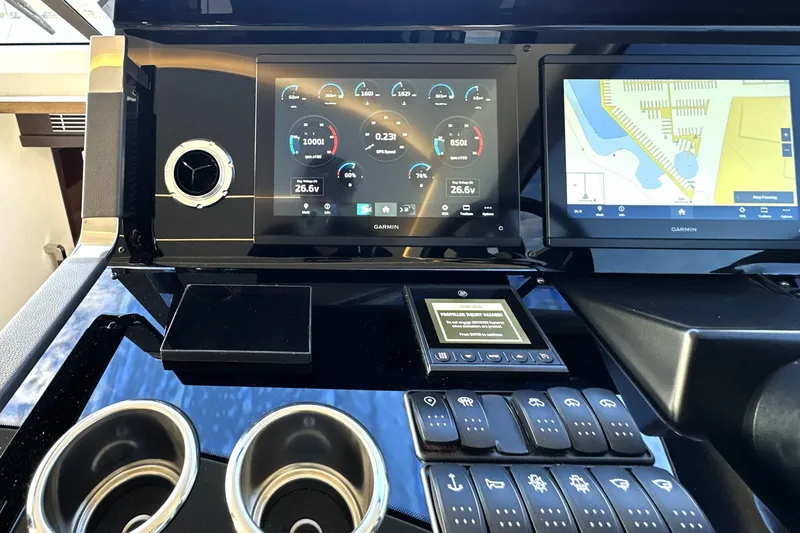 Slide: The Image of Control panel of 2023 Prestige 590 yacht with Garmin navigation displays and controls. - 55