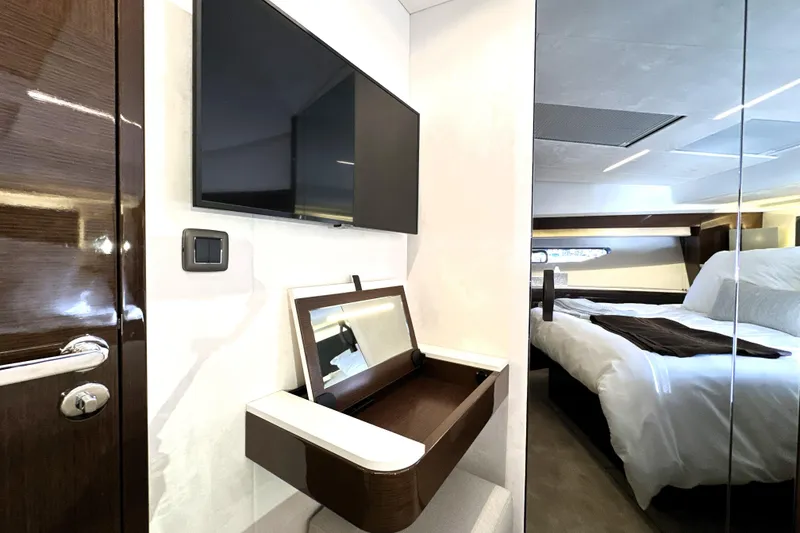 Slide: The Image of Luxurious interior of 2023 Prestige 590 yacht with modern bedroom and sleek TV setup. - 59