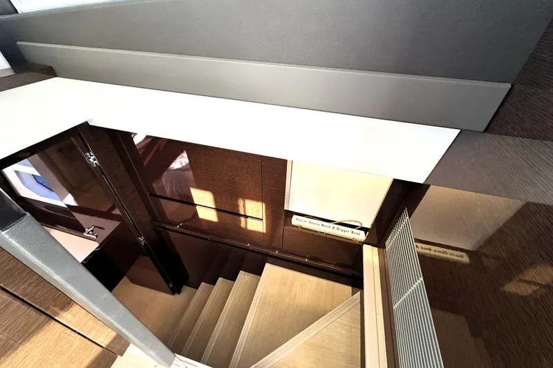 Slide: The Image of Staircase inside 2023 Prestige 590 yacht, featuring modern wood paneling and sleek design. - 68