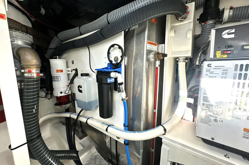 Slide: The Image of Engine room of 2023 Prestige 590 yacht with Cummins components and filtration system. - 82