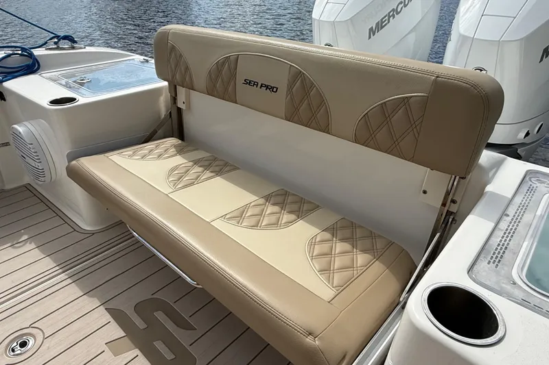 Slide: The Image of 2023 Sea Pro 320 DLX Offshore boat with tan cushioned seating and dual Mercury engines. - 12