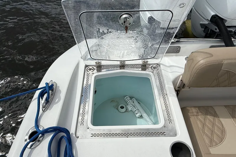 Slide: The Image of 2023 Sea Pro 320 DLX Offshore boat with open storage compartment and blue rope. - 14