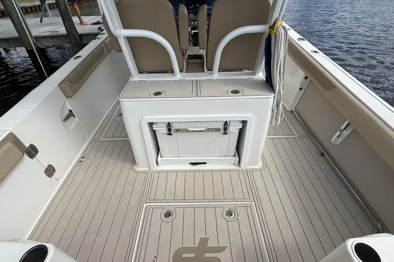 Slide: The Image of 2023 Sea Pro 320 DLX Offshore boat interior with seating and storage, dockside view. - 22