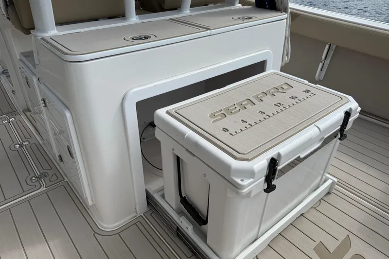 Slide: The Image of 2023 Sea Pro 320 DLX Offshore boat interior with storage and cooler. - 23