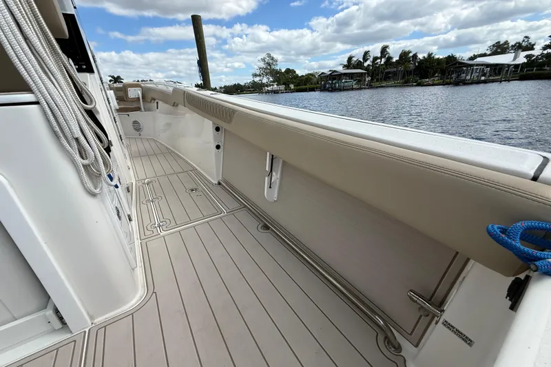 Slide: The Image of 2023 Sea Pro 320 DLX Offshore boat deck with ropes, docked by a scenic river. - 27