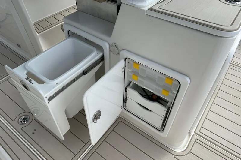 Slide: The Image of 2023 Sea Pro 320 DLX Offshore boat storage compartments and cooler on deck. - 30