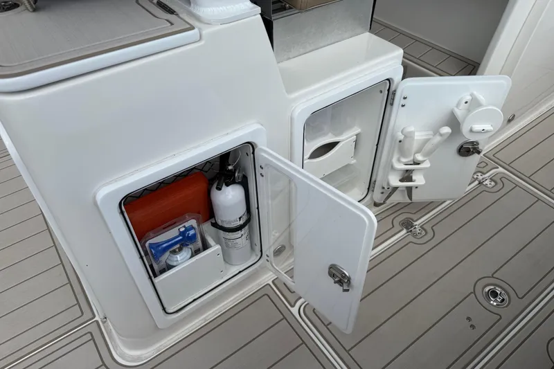 Slide: The Image of 2023 Sea Pro 320 DLX Offshore storage compartments with safety equipment and accessories. - 33