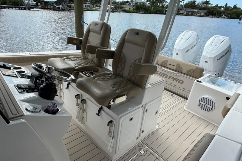 Slide: The Image of 2023 Sea Pro 320 DLX Offshore boat interior with dual captain chairs and Mercury engines. - 34