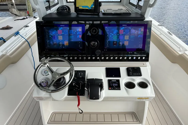 Slide: The Image of 2023 Sea Pro 320 DLX Offshore helm with dual Simrad displays and modern controls. - 39