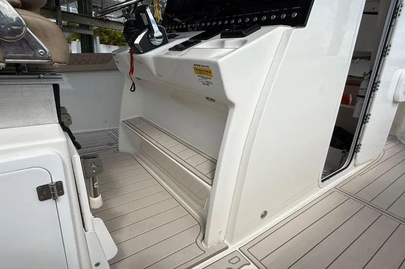 Slide: The Image of 2023 Sea Pro 320 DLX Offshore boat interior with helm and seating area. - 55