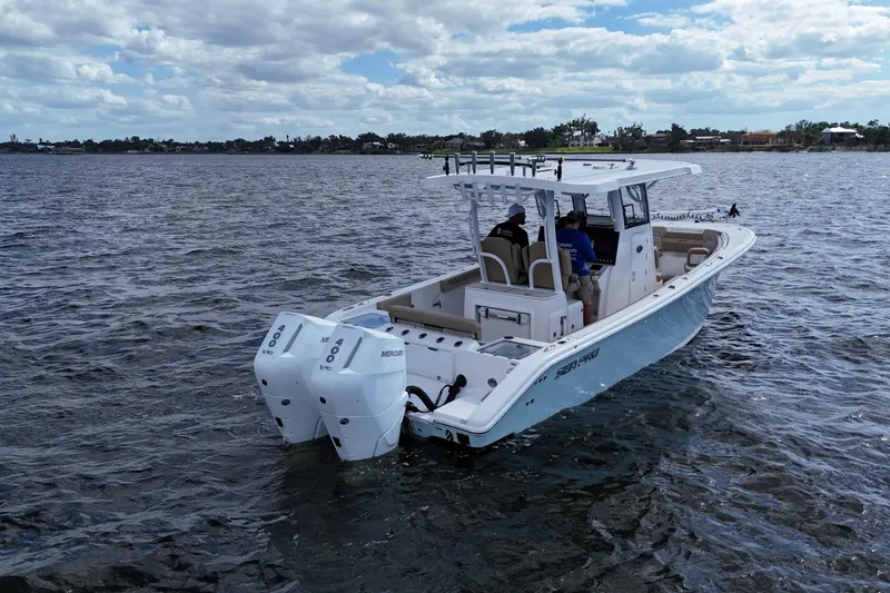 Slide: The Image of 2023 Sea Pro 320 DLX Offshore boat cruising on open water under cloudy skies. - 6