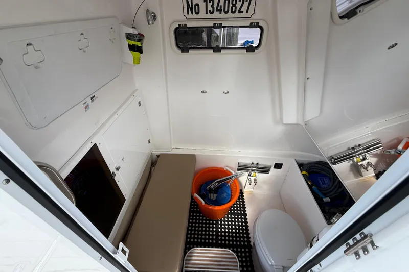 Slide: The Image of 2023 Sea Pro 320 DLX Offshore cabin interior with storage, seating, and marine equipment. - 61