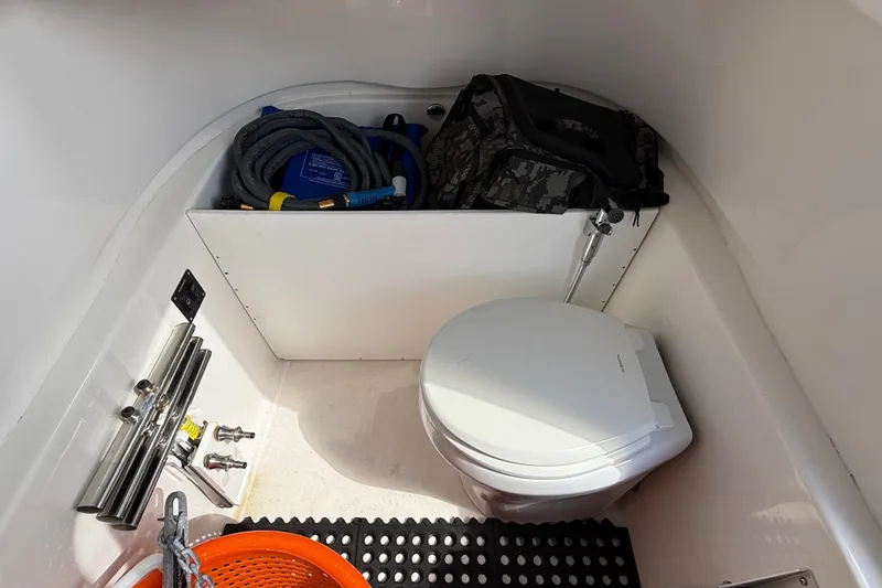 Slide: The Image of 2023 Sea Pro 320 DLX Offshore boat interior with toilet and storage area. - 63