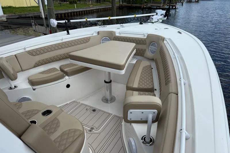 Slide: The Image of 2023 Sea Pro 320 DLX Offshore boat interior with beige seating and table. - 68