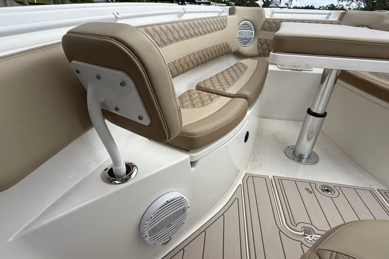 Slide: The Image of 2023 Sea Pro 320 DLX Offshore boat interior with tan cushioned seating and table. - 73