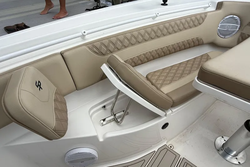 Slide: The Image of 2023 Sea Pro 320 DLX Offshore boat interior with beige quilted seating and speaker. - 74