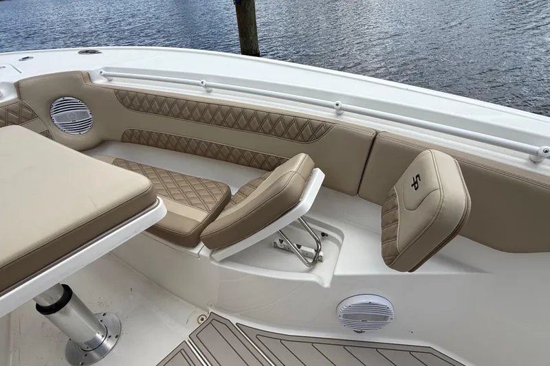 Slide: The Image of 2023 Sea Pro 320 DLX Offshore boat interior with tan cushioned seating and table. - 76