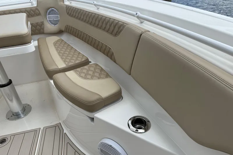 Slide: The Image of 2023 Sea Pro 320 DLX Offshore boat interior with beige cushioned seating. - 77
