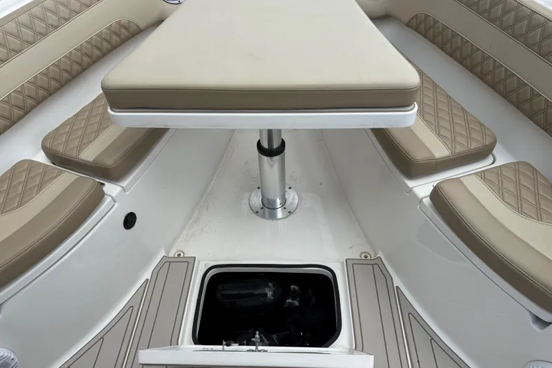 Slide: The Image of 2023 Sea Pro 320 DLX Offshore boat interior with cushioned seating and table. - 78