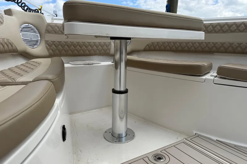 Slide: The Image of 2023 Sea Pro 320 DLX Offshore boat interior with cushioned seating and table. - 79