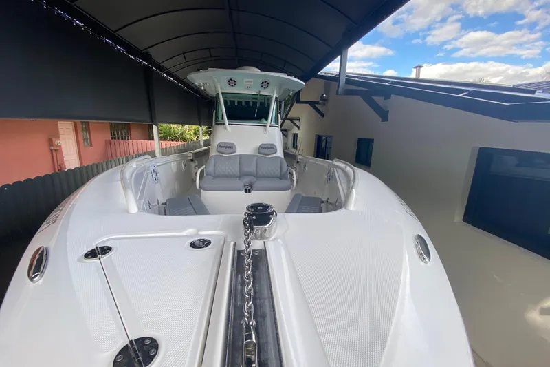 Slide: The Image of 2006 Everglades 290 Center Console boat under canopy, showcasing spacious deck and seating. - 14