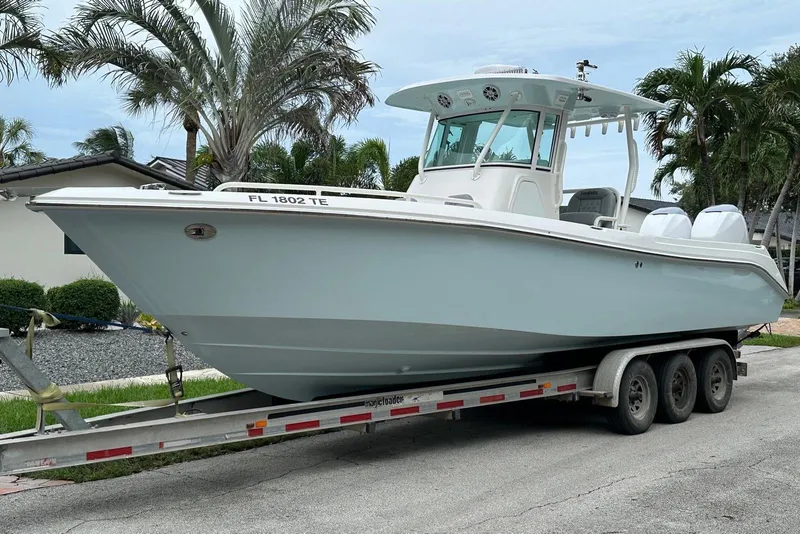 Slide: The Image of 2006 Everglades 290 Center Console boat on trailer, parked near palm trees. - 6