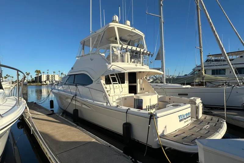 Slide: The Image of 2005 Riviera 47 Open Flybridge yacht cruising on open sea under clear skies. - 1