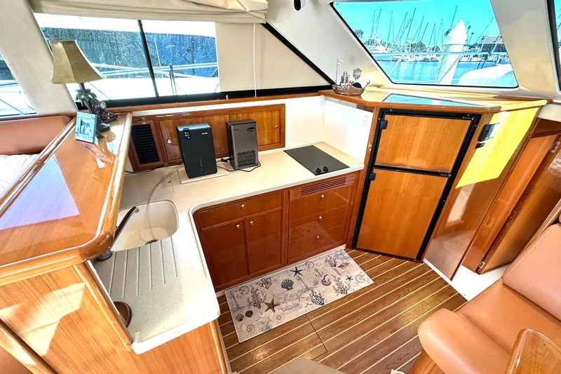 Slide: The Image of Luxurious interior of 2005 Riviera 47 Open Flybridge yacht with leather seating and wooden table. - 10