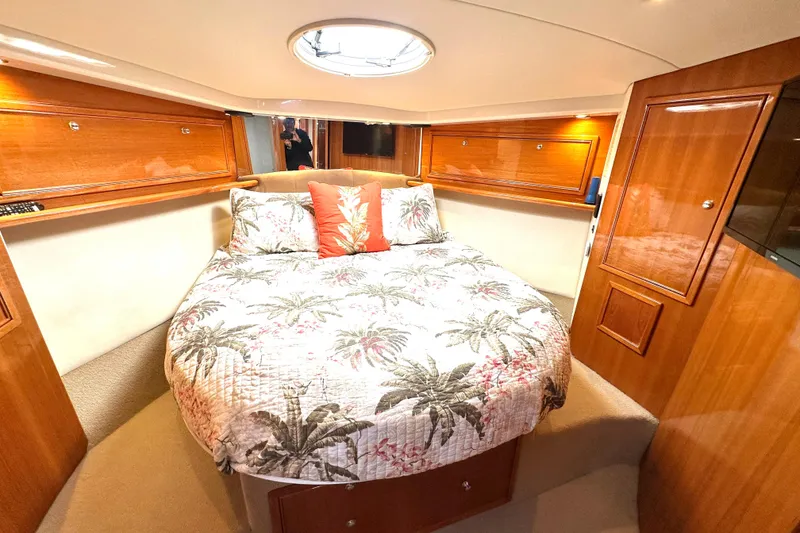 Slide: The Image of 2005 Riviera 47 Open Flybridge yacht interior with kitchenette, wooden cabinetry, and scenic marina view. - 13