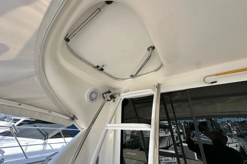 Slide: The Image of 2005 Riviera 47 Open Flybridge cabin with twin beds, wooden cabinetry, and a wall-mounted TV. - 20