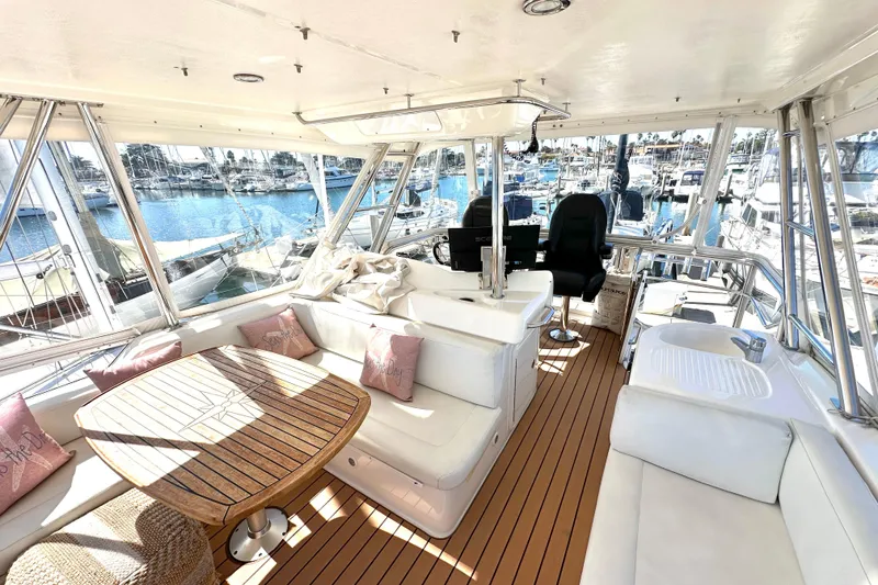 Slide: The Image of 2005 Riviera 47 Open Flybridge yacht docked in a marina under clear blue skies. - 25