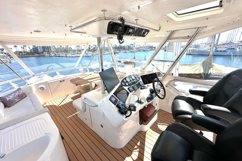 Slide: The Image of 2005 Riviera 47 Open Flybridge helm with leather seats and marina view. - 26