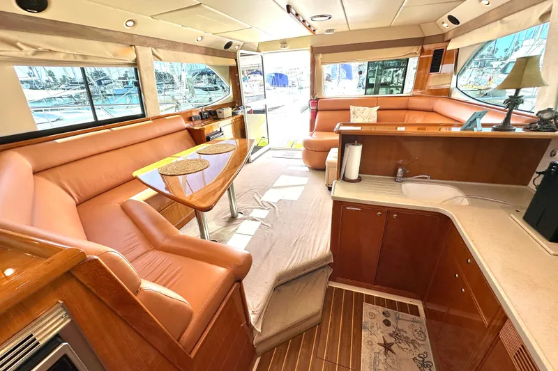 Slide: The Image of 2005 Riviera 47 Open Flybridge yacht on calm waters near a coastal city. - 3