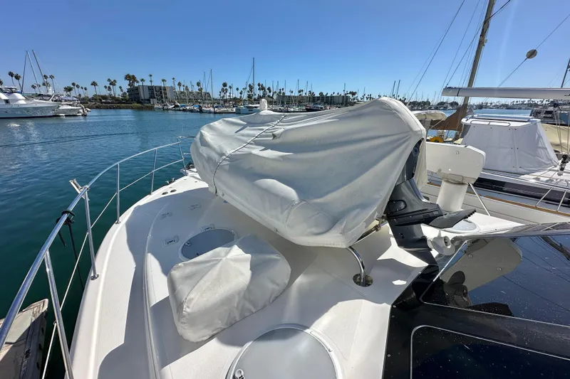 Slide: The Image of 2005 Riviera 47 Open Flybridge yacht docked in marina, covered equipment on deck. - 34