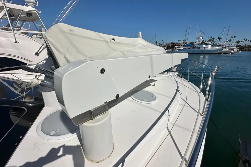 Slide: The Image of 2005 Riviera 47 Open Flybridge yacht deck with covered equipment, docked in a marina. - 35
