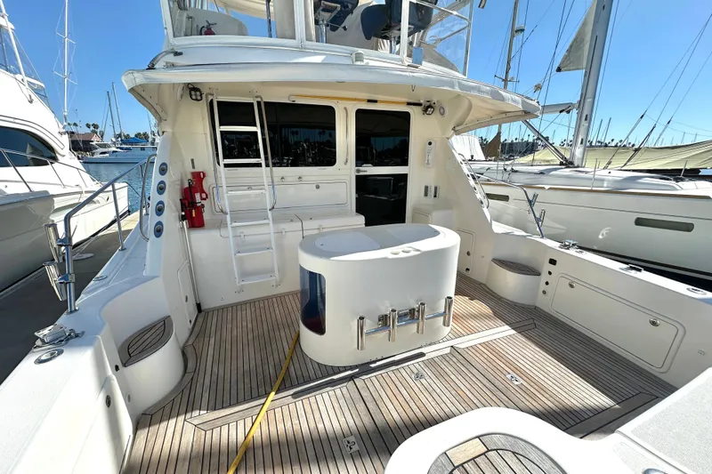 Slide: The Image of 2005 Riviera 47 Open Flybridge yacht deck with ladder, seating, and ocean view. - 36
