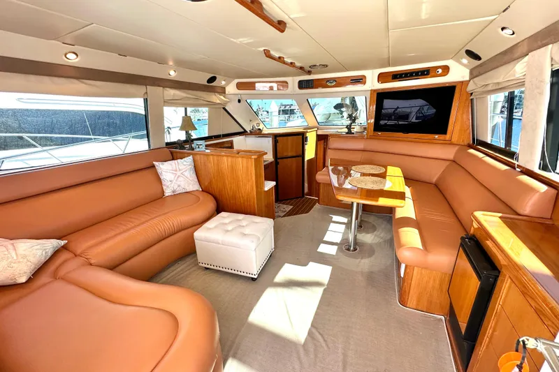 Slide: The Image of 2005 Riviera 47 Open Flybridge yacht docked at marina under clear blue sky. - 4