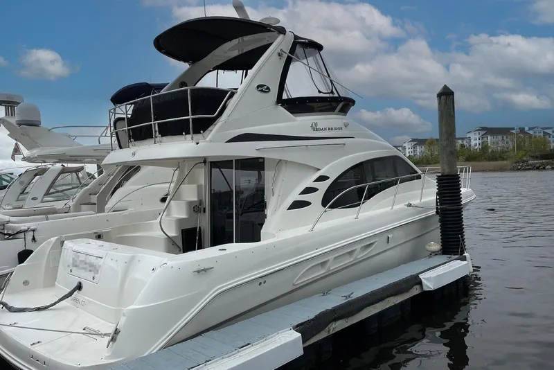 The Image of 2004 Sea Ray 420 Sedan Bridge yacht docked at marina under blue sky. - 1