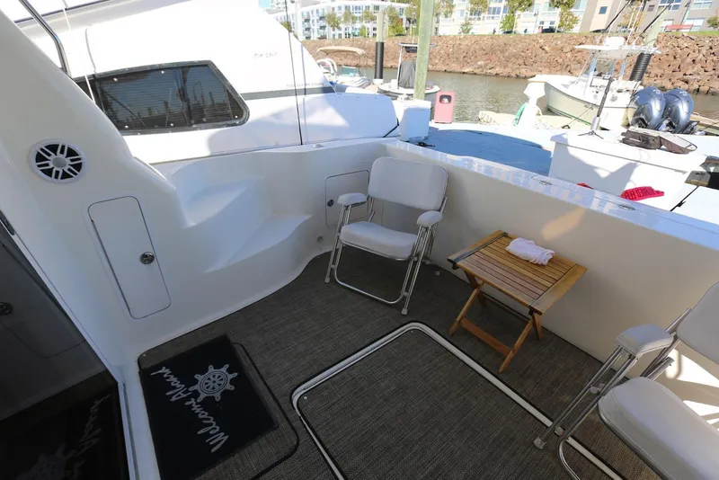Slide: The Image of 2004 Sea Ray 420 Sedan Bridge yacht deck with chairs and table, docked at marina. - 11