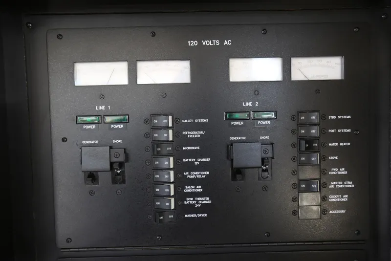 Slide: The Image of Electrical control panel of a 2004 Sea Ray 420 Sedan Bridge yacht, showing power switches and meters. - 117