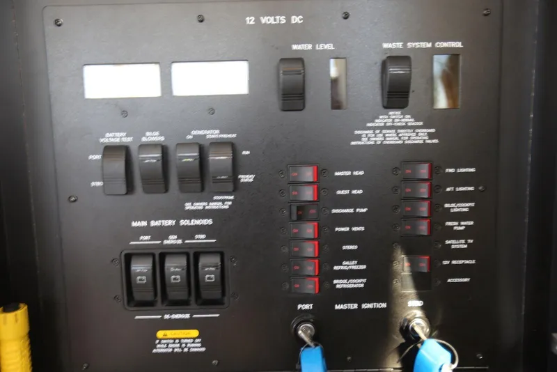Slide: The Image of Control panel of a 2004 Sea Ray 420 Sedan Bridge yacht, featuring various switches and indicators. - 118