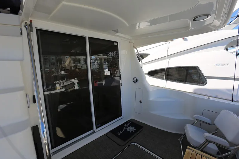 Slide: The Image of 2004 Sea Ray 420 Sedan Bridge yacht deck with sliding glass doors and seating area. - 14
