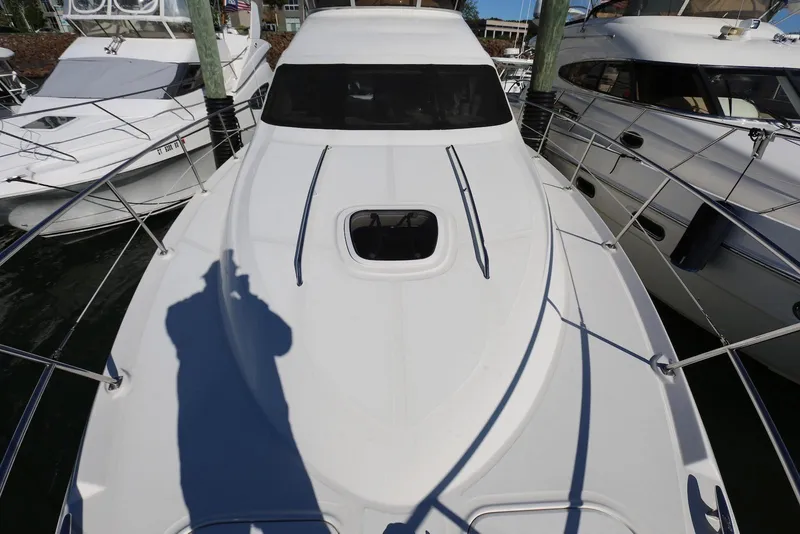 Slide: The Image of 2004 Sea Ray 420 Sedan Bridge yacht docked between two boats. - 25