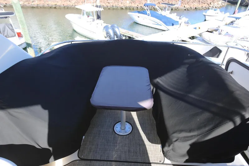 Slide: The Image of 2004 Sea Ray 420 Sedan Bridge yacht with covered seating area and table on deck. - 36