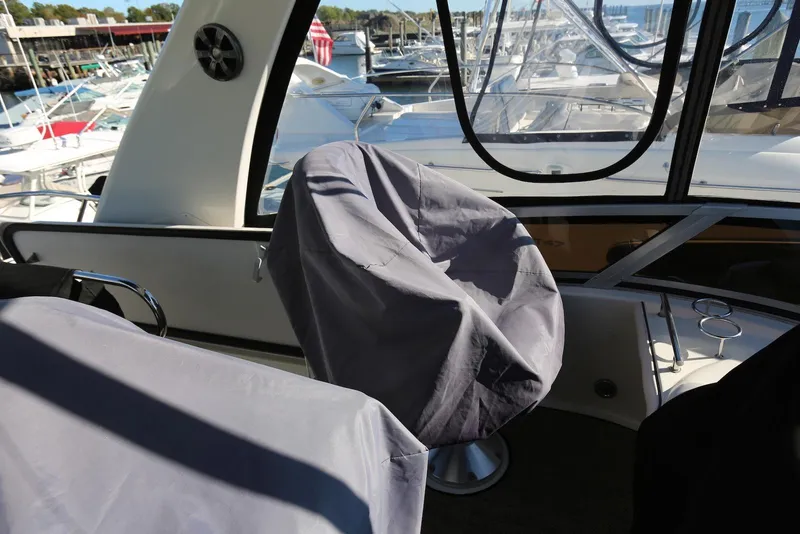 Slide: The Image of 2004 Sea Ray 420 Sedan Bridge interior with covered seats and marina view. - 37