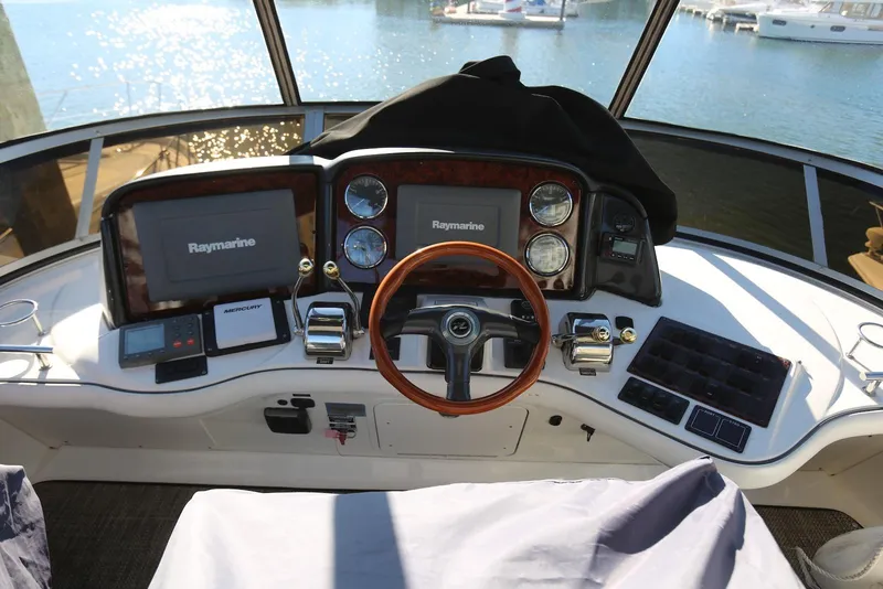 Slide: The Image of Helm of 2004 Sea Ray 420 Sedan Bridge with Raymarine displays and wooden steering wheel. - 39