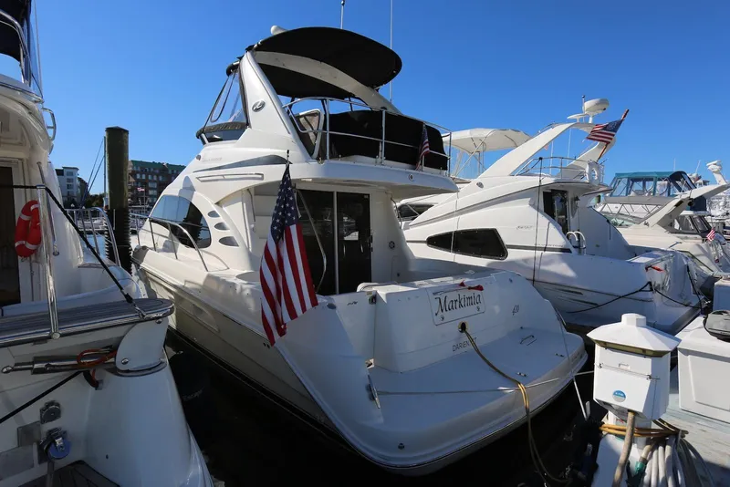 Slide: The Image of 2004 Sea Ray 420 Sedan Bridge yacht docked at marina, American flag displayed. - 4