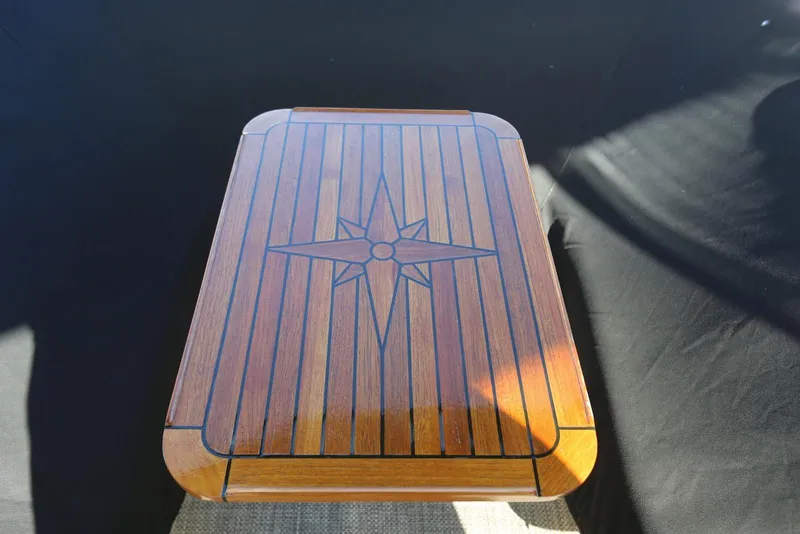 Slide: The Image of Wooden table with compass rose design on a 2004 Sea Ray 420 Sedan Bridge. - 56