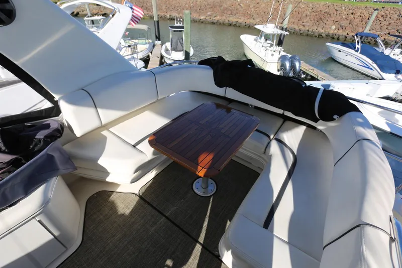 Slide: The Image of Luxurious seating area on 2004 Sea Ray 420 Sedan Bridge yacht, featuring elegant wooden table. - 57